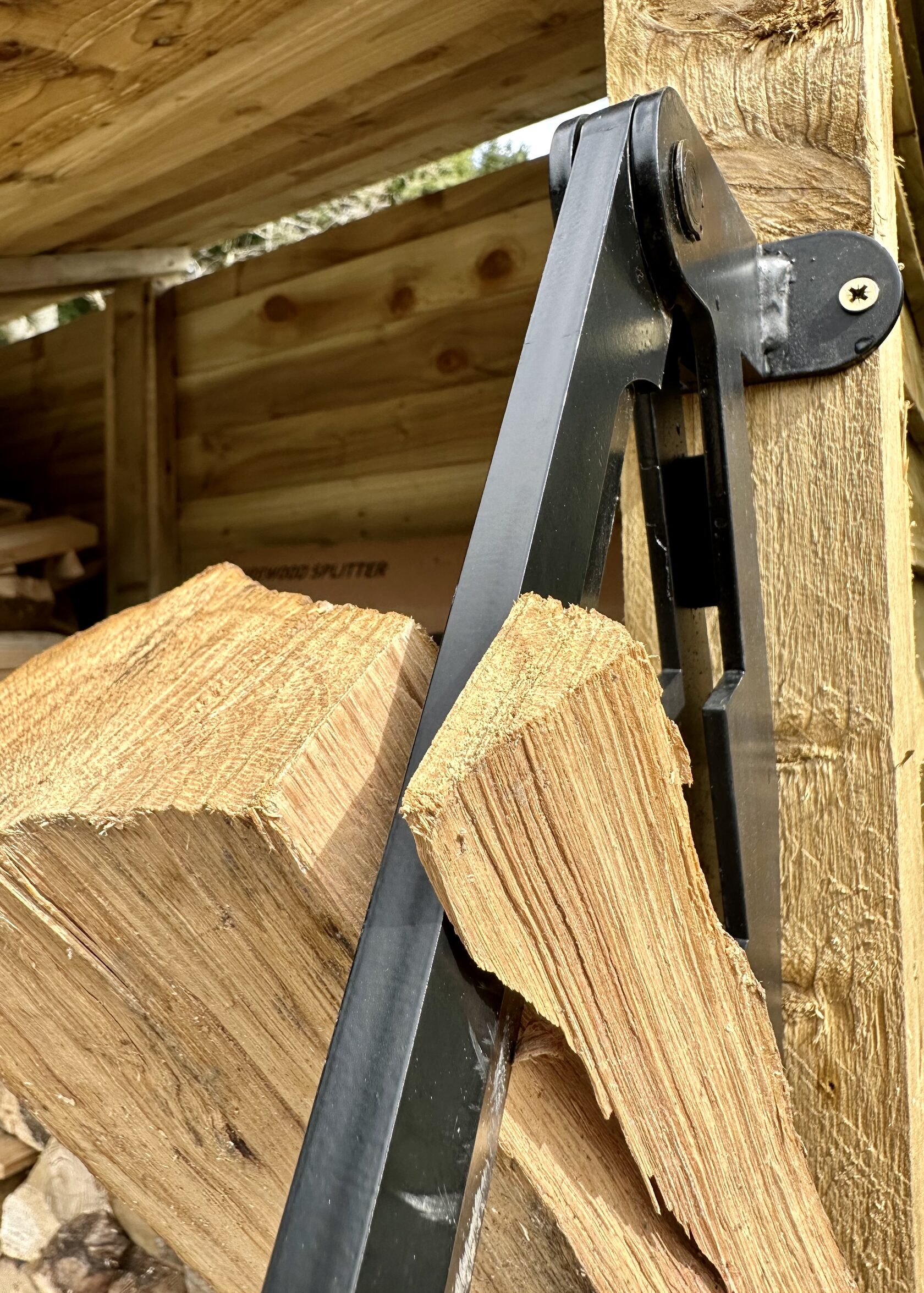 Mid-split — blade biting into oak, corner-first